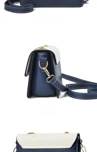 Detail view of the accordion-style gusset and gold hardware on blue leather crossbody bag