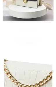Close-up of crocodile embossed white leather with gold chain strap and metal lock detail