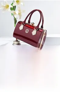 Detail of burgundy patent leather evening bag with golden hardware and crystal clasp