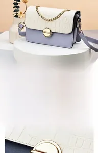 Detail of elegant two-tone faux leather bag with gold rotary lock and thick chain strap