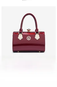 Detailed view of red patent leather evening bag with rhinestone clasp and floral metal hardware