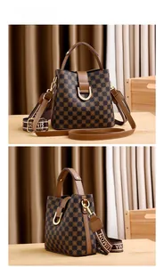 Détail du sac seau à damier avec fermoir doré et bandoulière brodée
