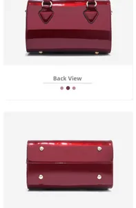 Close-up of dark red patent leather bag with gold metal feet at the bottom