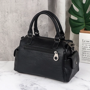 Black large capacity soft leather boston bag with stylish metal hardware on marble surface