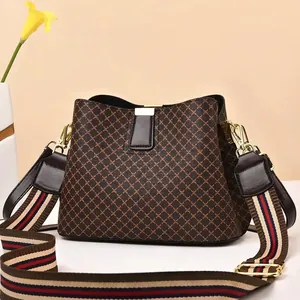 Detailed macro view of brown diamond pattern bucket bag with striped canvas wide shoulder strap