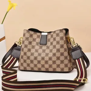 Close-up of bucket bag showing checkerboard floral pattern and striped woven shoulder strap
