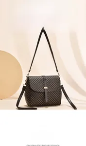 Dettaglio borsa vintage a tracolla con trama geometrica e fibbia in metallo dorato