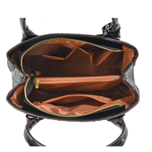 Detail of black crocodile embossed bag with multi-layer interior and gold zipper hardware