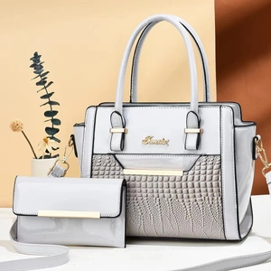 Détail de l'ensemble de sacs gris clair motif crocodile avec logo doré et pochette assortie