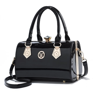 Elegant black patent leather cylinder evening bag with gold floral hardware and top handle