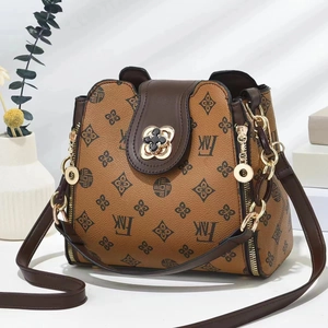 Retro monogram crossbody bucket bag with caramel leather trim and gold clover clasp