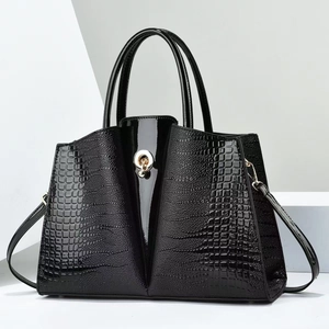 Détail du sac cabas noir avec cuir gaufré croco, couture vernie et boucle dorée