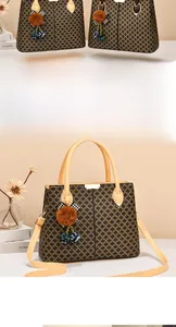 Détail du sac fourre-tout avec motif géométrique, poignées en cuir et pompon décoratif