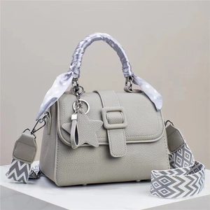 Sac à main gris texture litchi avec pendentif étoile et foulard à pois sur l'anse