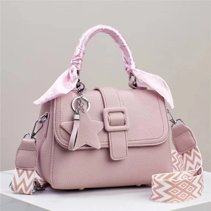 Détail du sac à main en cuir rose avec poignée en soie et bandoulière géométrique