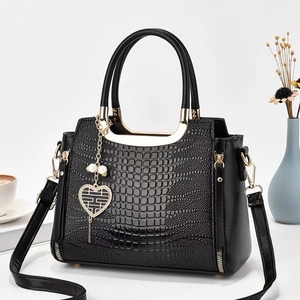 Grand sac à main noir motif crocodile avec pendentif cœur doré et poignées rondes