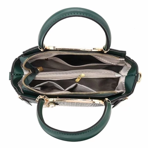 Détail de l'intérieur d'un sac cabas vert foncé avec compartiments et breloques dorées