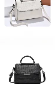 Detail view of white crocodile pattern handbag with silver metal trim and top handle