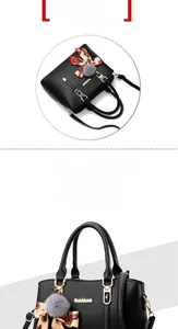 Détail d'un sac à main en cuir noir avec foulard en soie rouge et pompon en fourrure grise