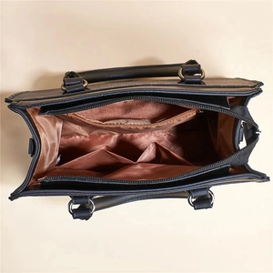 Detail view of the spacious brown interior with a secure zipper pocket in a black tote bag