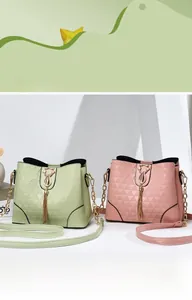 Détail de sacs seaux matelassés avec pendentif chat et franges en rose et vert