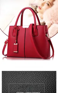 Vista dettagliata della trama in pelle PU rossa con grana litchi e hardware in metallo dorato