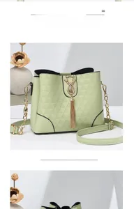 Détail du sac seau matelassé vert clair avec fermoir chat doré et pompon chaîne