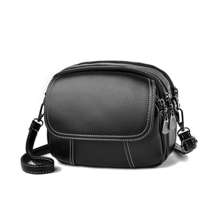 Black pebbled leather crossbody bag with white contrast stitching and triple zippers
