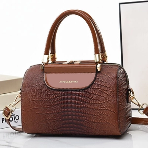 Dark brown lizard embossed Boston bag with gold hardware and top handles shown from a side angle