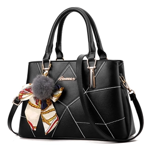 Sac à main noir matelassé avec coutures blanches et foulard floral sur la poignée