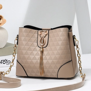 Sac seau bandoulière beige élégant avec motif géométrique gaufré et pendentif chat doré