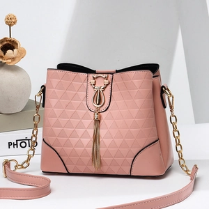 Sac seau rose gaufré avec boucle chat dorée et pompon sur des blocs géométriques