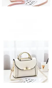 Close-up of cream handbag featuring a golden round twist lock and V-stitch detailing