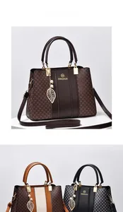 Détail du sac à bandoulière imprimé avec doubles poignées et logo de marque en métal