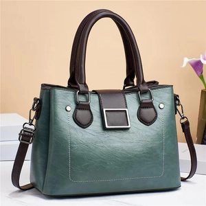 Detail of vintage contrast color handbag with silver metal buckle and textured leather finish