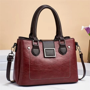Close-up of vintage burgundy crossbody bag featuring contrast stitching and magnetic buckle