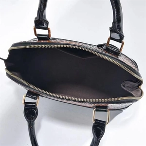 Makroaufnahme von geprägtem PU-Leder mit Tiermuster und polierten Goldmetall-Elementen