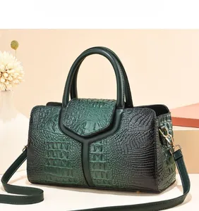 Detail of dark green ostrich pattern tote bag with gold hardware and V-shaped stitching