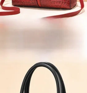 Macro shot of wine red ostrich textured leather handbag base and reinforced stitching