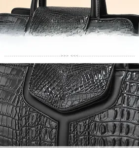 Detail of comfortable handle with precise stitching on black ostrich texture handbag