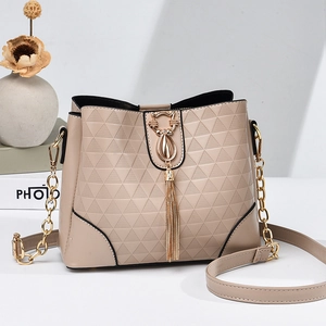 Beige bucket bag with geometric embossed pattern, golden cat tassel, and chain strap