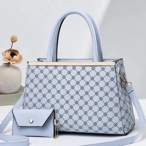 Détail du grand sac cabas bleu clair avec motif monogramme et petite pochette assortie