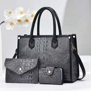 Detailed close-up of three-piece black crocodile pattern tote bag set with golden hardware