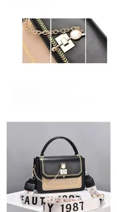 Close-up of contrast stitch handbag featuring wide fabric strap and golden metal chain