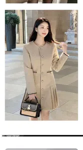 Detail of camel wool coat with contrast knit trim and matching two-tone handbag