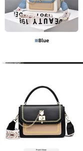Detail of crossbody bag with golden cat-shaped metal lock and ethnic jacquard wide strap