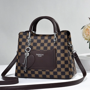 Detail of checkered print handbag with FASHION Queen pocket and heart pendant charm