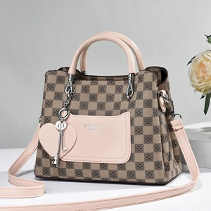Close-up of pink leather pocket with fashion queen text and heart charm on handbag