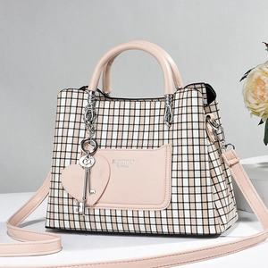 Detail of pink plaid tote bag featuring Fashion Queen logo and heart key charms