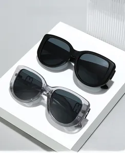 Detail showing oversized cat-eye sunglasses with metal H hinge on white pedestals